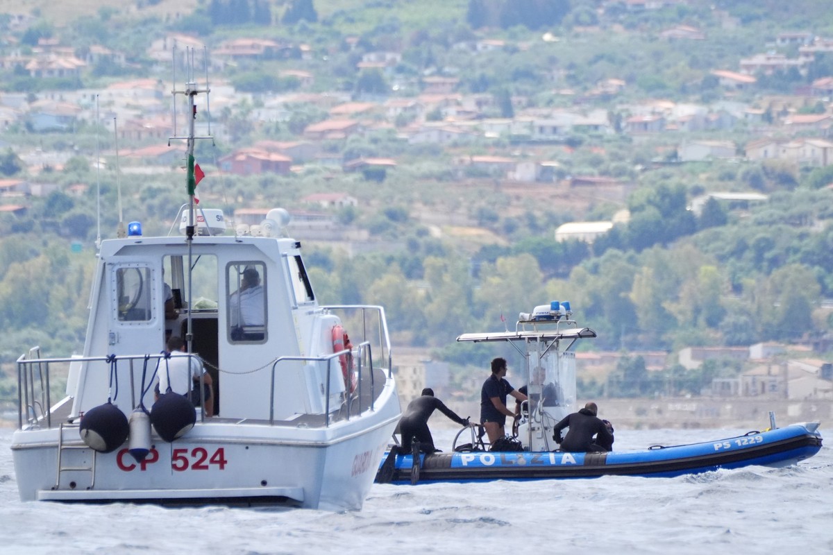21.08.2024, Italien, Palermo: Taucher der italienischen Polizei stehen auf einem Festrumpfschlauchboot (RiB) in der N