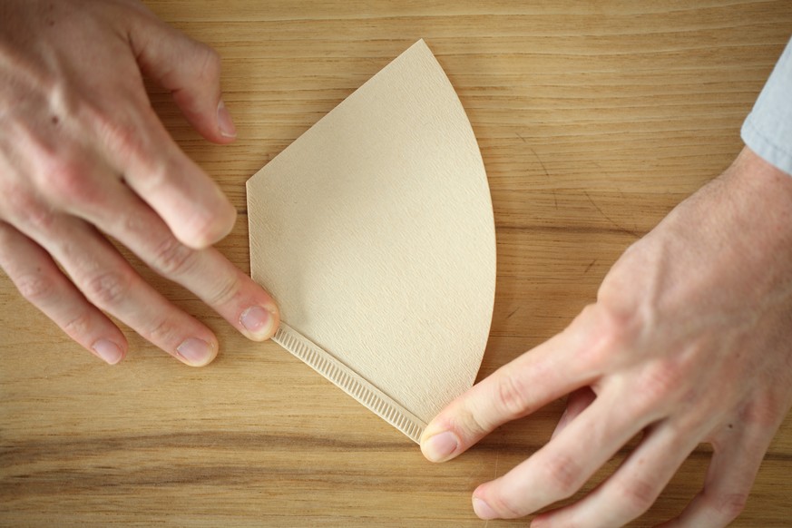 Close up of hands of person holding coffee filter, Oakland, California, USA