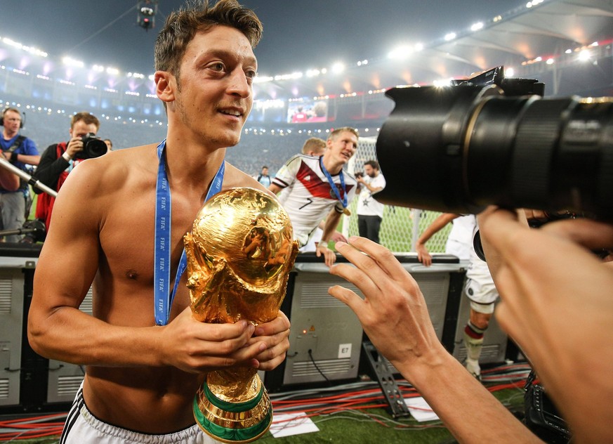 Football - 2014 FIFA World Cup, WM, Weltmeisterschaft, Fussball - Final - Germany v Argentina 13 July 2014 - FIFA World Cup - Final - Germany v Argentina - Mesut Ozil of Germany holds the world cup tr ...