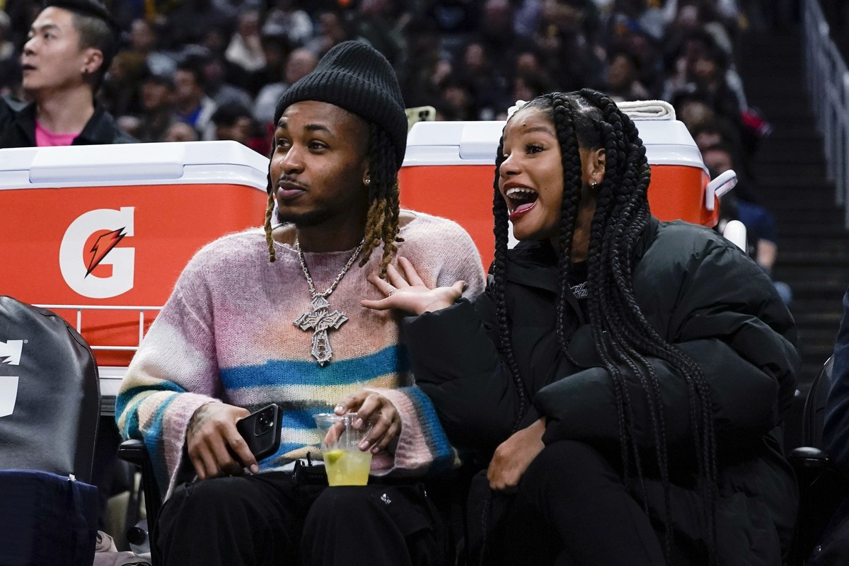 Rapper DDG, left, and singer Halle Bailey watch during the second half of an NBA basketball game between the Los Angeles Clippers and the Golden State Warriors, Thursday, Dec. 14, 2023, in Los Angeles ...