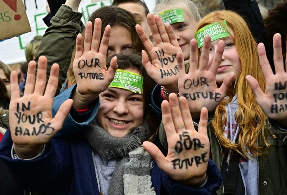 TOPSHOT - Youths show their hands bearing the inscriptions &quot;Our future in your hands&quot; during the &quot;Fridays For Future&quot; movement on a global day of student protests aiming to spark w ...