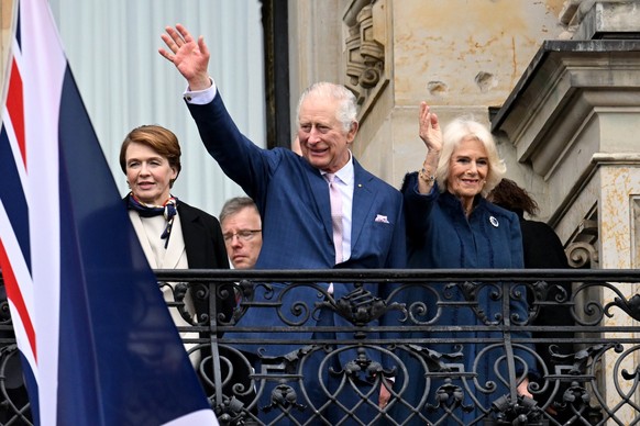 31.03.2023, Hamburg: König Charles III. von Großbritannien (M) und Königsgemahlin Camilla (r) winken neben Elke Büdenbender (l), Ehefrau des Bundespräsidenten, auf dem Balkon vom Hamburger Rathaus. Zu ...