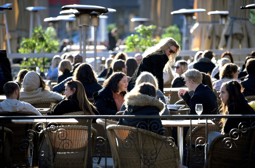 FILE PHOTO: People enjoy the sun at an outdoor restaurant, despite the continuing spread of the coronavirus disease (COVID-19), in Stockholm, Sweden March 26, 2020. TT News Agency/Janerik Henriksson v ...