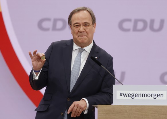 North Rhine-Westphalia&#039;s Governor and candidate as leader of the Christian Democratic Union (CDU) Armin Laschet shows a luck coin offered to him by his father as he delivers his speech on the sec ...