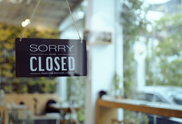 Business coffee cafe shop sign board is hang on door and show &quot;Sorry We are Closed&quot; with cafe and resturant blur bokeh background.