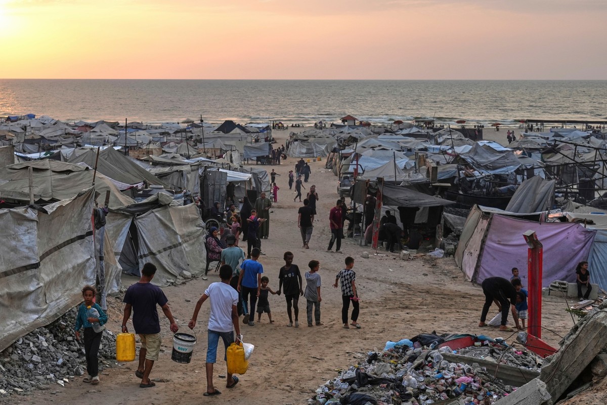 ARCHIV - 10.08.2025, Palästinensische Gebiete, Gaza: Vertriebene Palästinenser gehen durch ein behelfsmäßiges Lager am Strand von Gaza-Stadt. (zu dpa: «Gaza-Plan wird Dienstag Vereidigungsminister vor ...