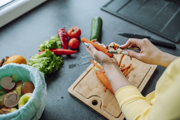 Hands of young woman peeling carrot in kitchen at home model released, Symbolfoto property released, OLRF00147