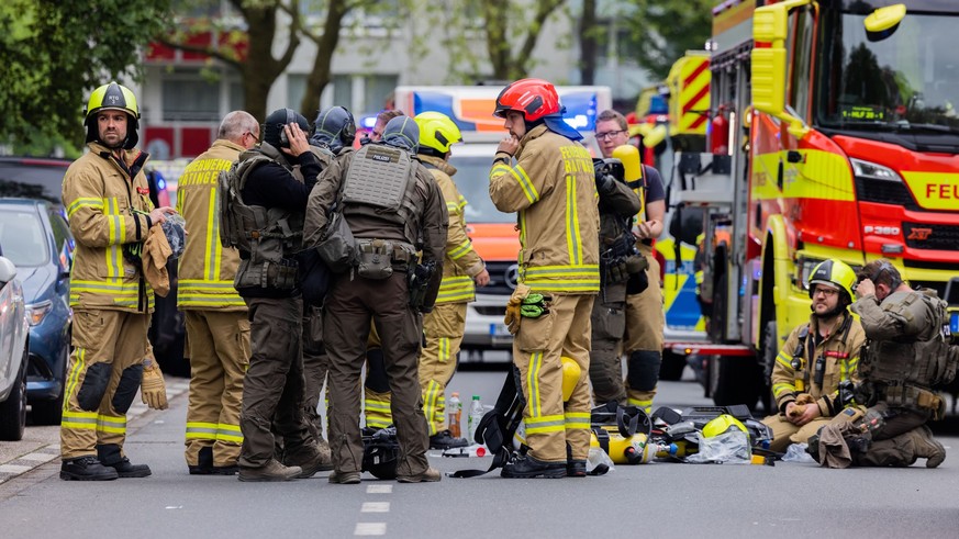 11.05.2023, Nordrhein-Westfalen, Ratingen: Polizeibeamte mit Gasmasken und Feuerwehrleute stehen vor einem Hochhaus. Bei einer Explosion in einem Hochhaus in Ratingen am Donnerstagvormittag wurden meh ...