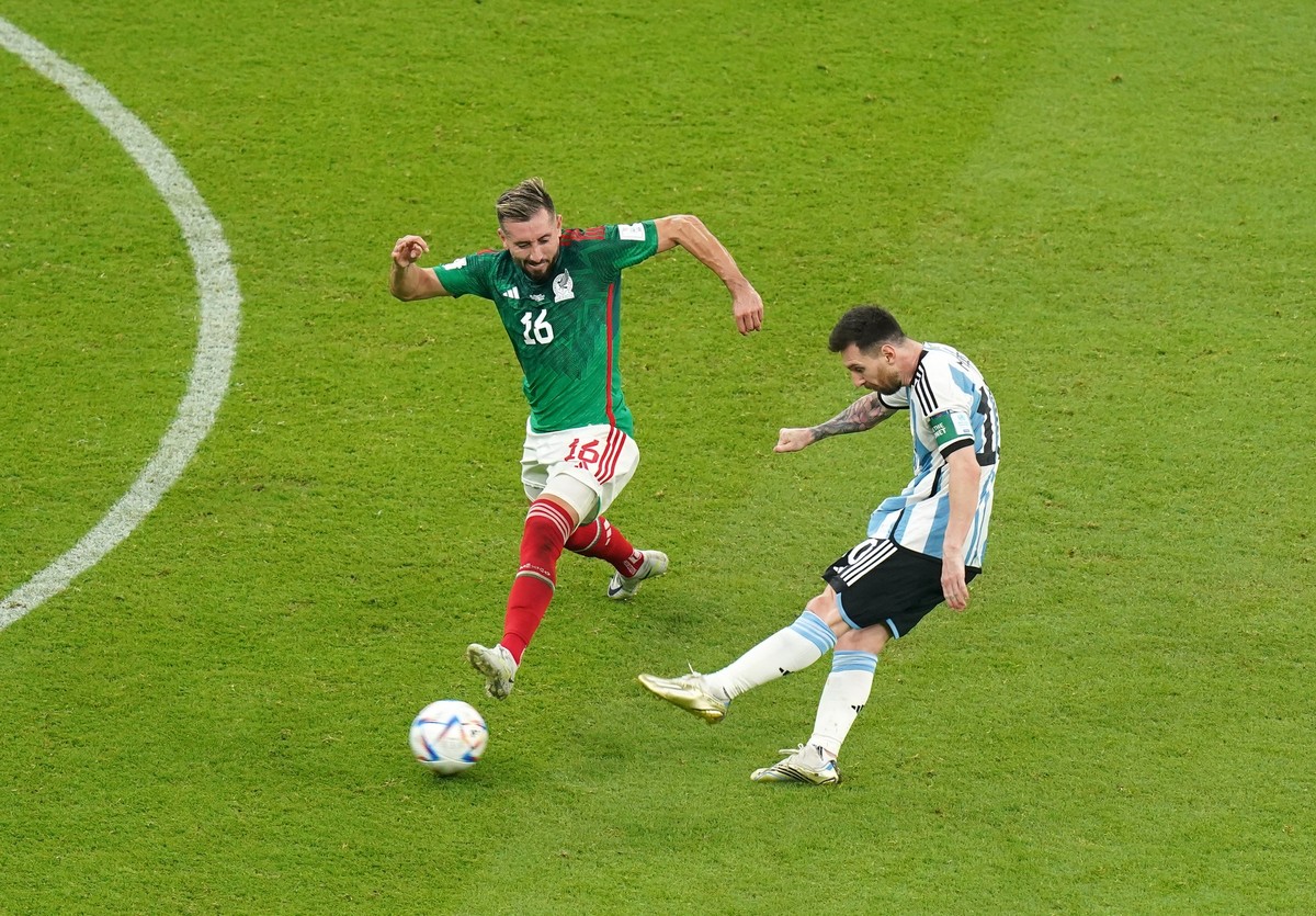 26.11.2022, Katar, Lusail: Fu�ball, WM, Argentinien - Mexiko, Vorrunde, Gruppe C, Spieltag 2, Lusail Iconic Stadion, Lionel Messi (r)�aus Argentinien schie0t gegen Hector Herrera aus Mexiko sein Tor z ...