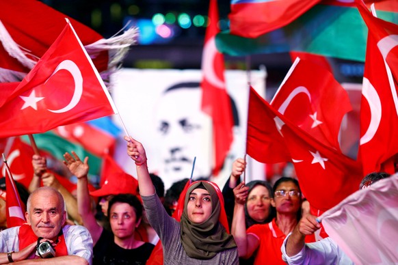 FILE PHOTO: Supporters of Turkish President Recep Tayyip Erdogan wave national flags as they listen to him through a giant screen in Istanbul&#039;s Taksim Square, Turkey, August 10, 2016. REUTERS/Osm ...
