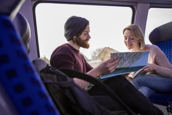 ILLUSTRATION - Ein Paar sitzt am 28.03.2018 in einer Regionalbahn von Hamburg nach Luebeck und schaut gemeinsam auf eine Landkarte (gestellte Szene). Foto: Christin Klose || Modellfreigabe vorhanden