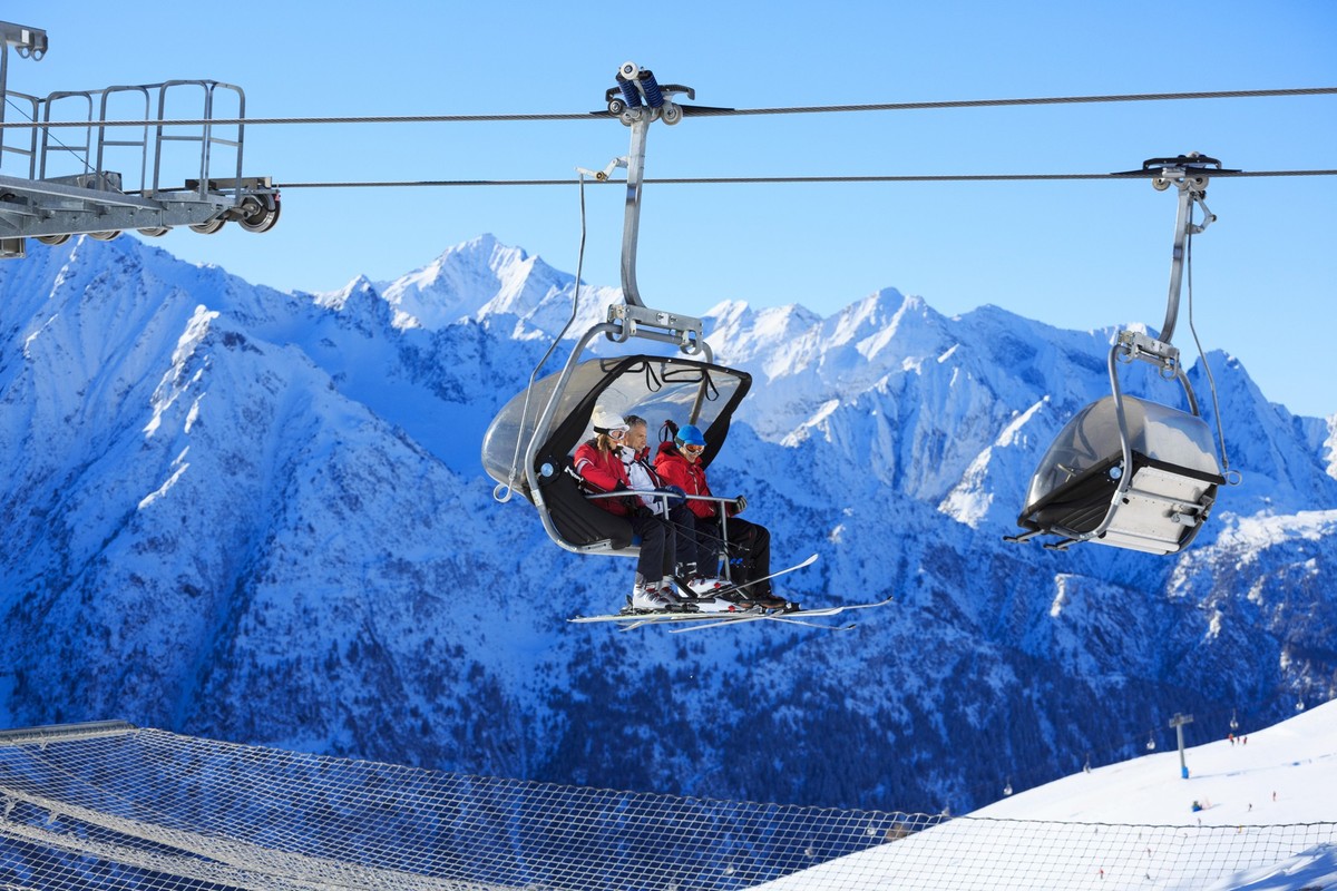 Happy skiers on the ski lift, going up.