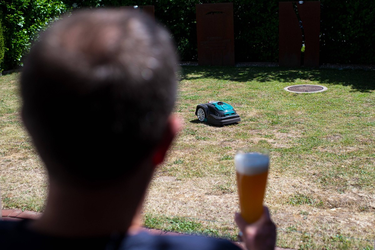 01.06.2020: Feature Alltag Ein Mann trinkt Weizenbier und schaut seinen Rasenroboter, Mähroboter an , Nordrhein-Westfalen Deutschland *** 01 06 2020 Feature Everyday life A man drinks wheat beer and l ...