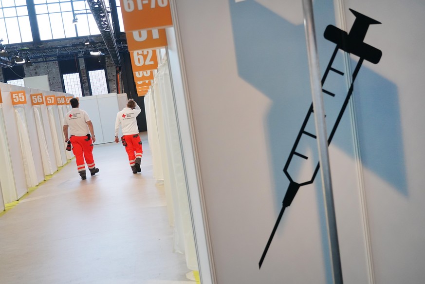 BERLIN, GERMANY - DECEMBER 21: Workers from the German Red Cross (DRK) walk among inoculation cabins at the completed Covid-19 vaccination center at the Arena Berlin events venue on December 21, 2020 ...