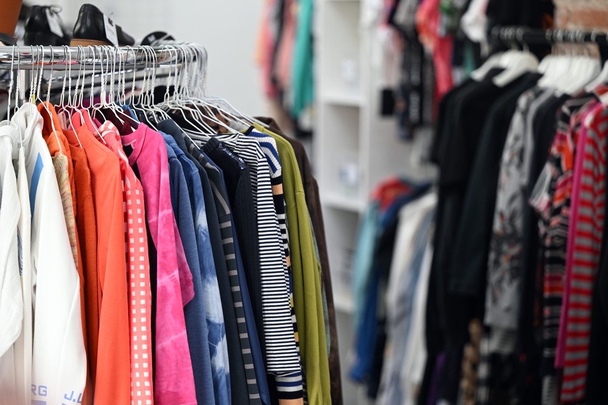 PRODUKTION - 19.08.2022, Nordrhein-Westfalen, Köln: Auf Kleiderbügeln hängt Bekleidung im Laden Kleiderei in Köln Ehrenfeld. Nach Köln, Freiburg und Berlin wird eine neue Filiale in Stuttgart eröffnet ...