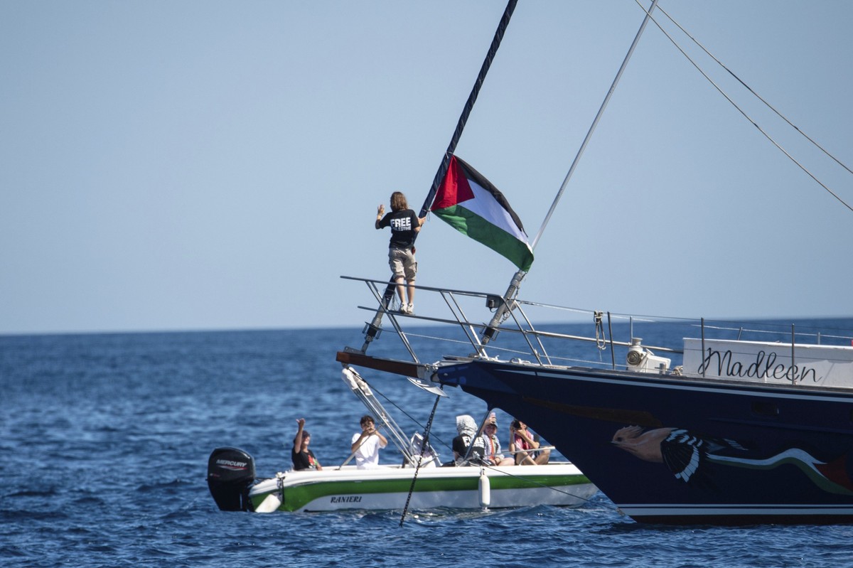 Climate activist Greta Thunberg stands near a Palestinian flag after boarding the Madleen boat and before setting sail for Gaza along with activists of the Freedom Flotilla Coalition, departing from t ...
