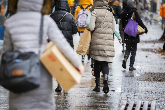 23.12.2023, Berlin: Passanten gehen mit Einkaufstaschen auf der Einkaufsmeile Schloßstraße im Stadtteil Steglitz. Foto: Christoph Soeder/dpa +++ dpa-Bildfunk +++