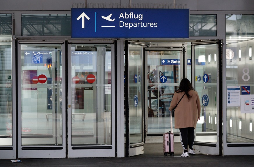 Eine Frau auf dem Weg zum Gate am Flughafen Düsseldorf. (Archivfoto)