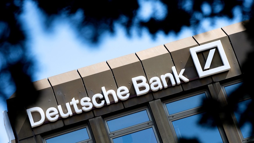 ARCHIV - 24.04.2021, Niedersachsen, Oldenburg: Das Logo und der Schriftzug der Deutschen Bank hängen an einer Filiale im Stadtzentrum. Die Deutsche Bank hat laut US-Medien einen millionenschweren Verg ...