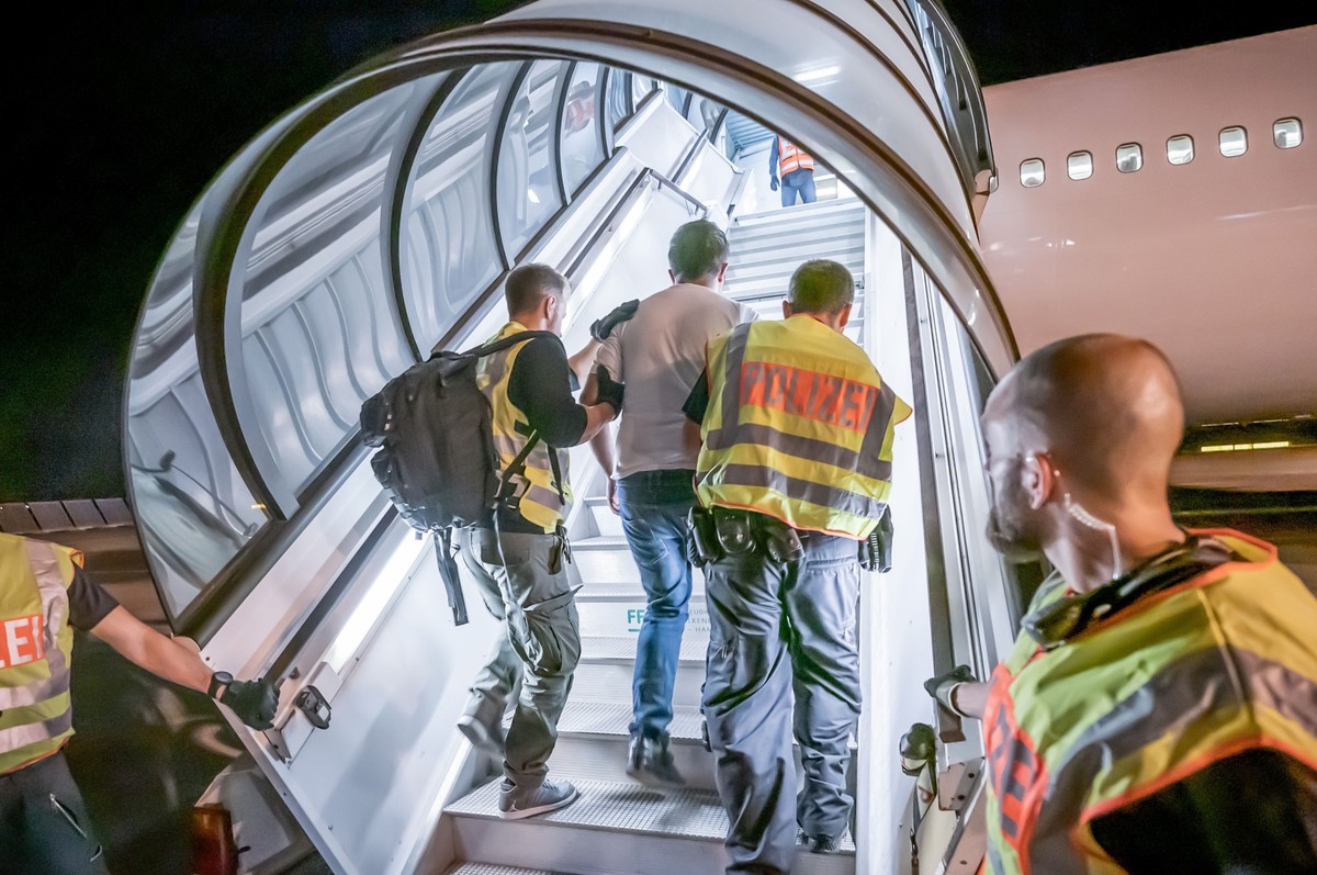 ARCHIV - 30.07.2019, Sachsen, Leipzig: Polizeibeamte begleiten einen Afghanen auf dem Flughafen Leipzig-Halle in ein Charterflugzeug. (zu dpa «Kabinettssitzung - voraussichtlich mit Gesetzentwurf zu A ...