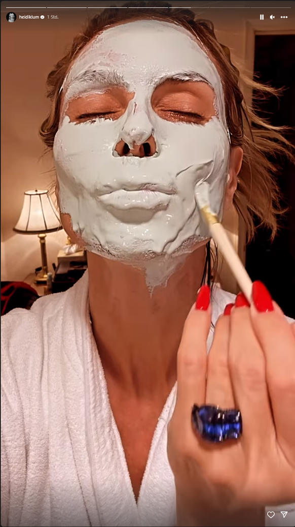 Heidi Klum zeigt, wie sie eine Beautymaske aufträgt.
