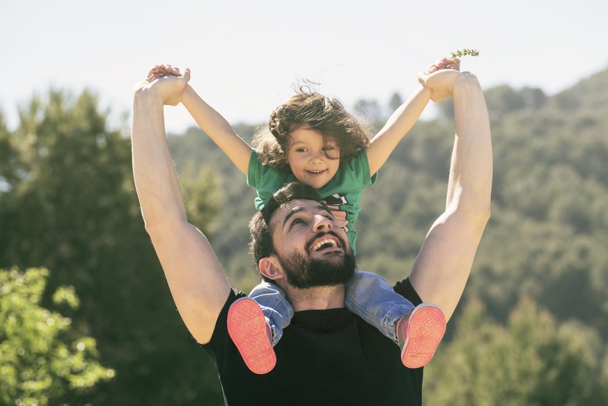 father and daughter playing outdoors in day light