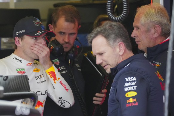 Red Bull driver Max Verstappen, left, of the Netherlands gestures as he talks to team principal Christian Horner and team director Helmut Marko, right, following the third practice session of the Aust ...