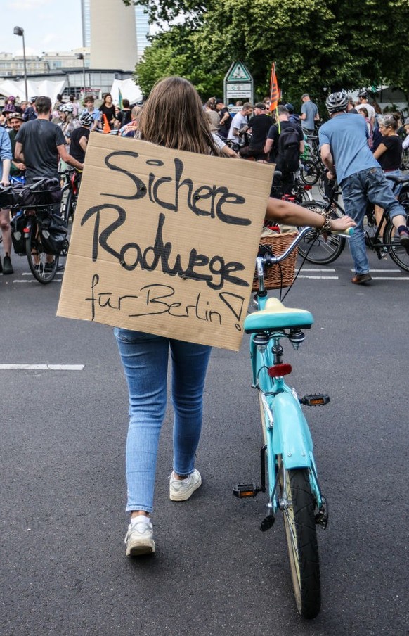 BERLIN, GERMANY - JULY 2: A demonstrator with a banner reading &quot;Secure bike-lanes for Berlin&quot; as activists protesting against the city government&#039;s halt on new bicycle lanes demonstrate ...
