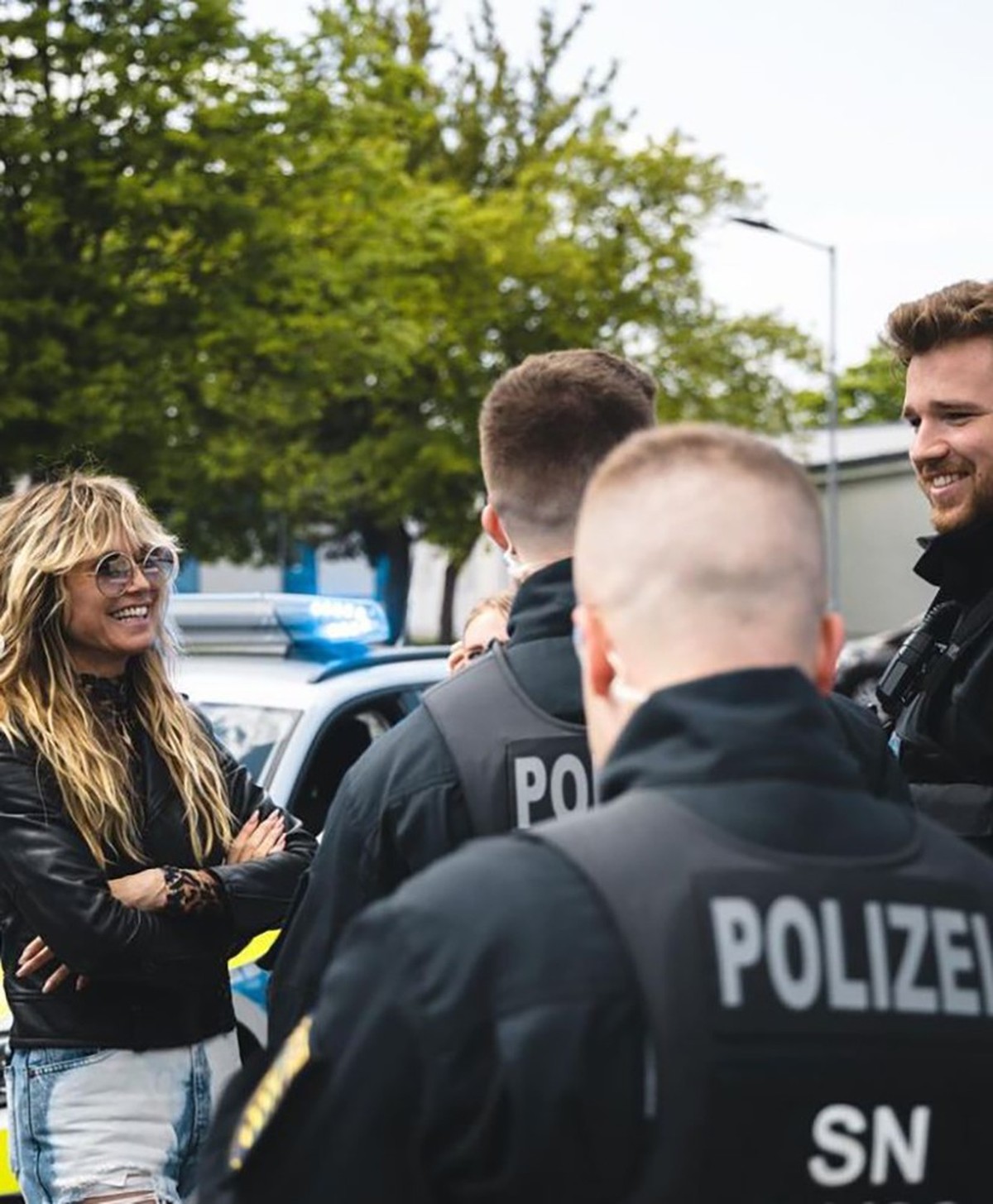 HANDOUT - 18.05.2023, Sachsen, Leipzig: Model Heidi Klum unterhält sich bei einem Besuch der Polizei mit Einsatzkräften. Zuvor hatten ihr Mann Tom und sein Bruder Bill Kaulitz von der Band Tokio Hotel ...