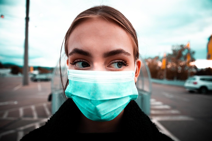 Young teenage woman wearing a protective surgical mask going to shop in the supermarket. Supermarket Parking Lot in the Background. Wide Angle Portrait. Covid-19 - Corona Virus Supermarket Concept Ser ...