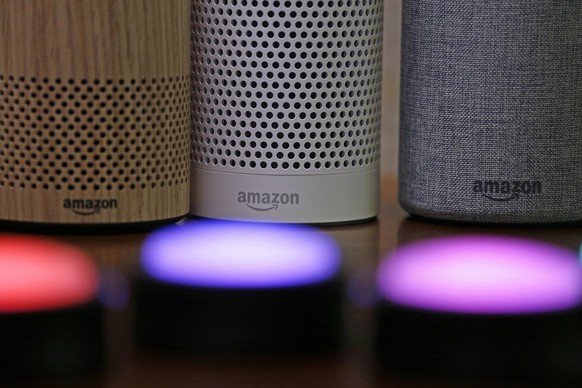 FILE - Amazon Echo and Echo Plus devices, behind, sit near illuminated Echo Button devices during an event announcing several new Amazon products by the company, Sept. 27, 2017, in Seattle. Amazon is  ...