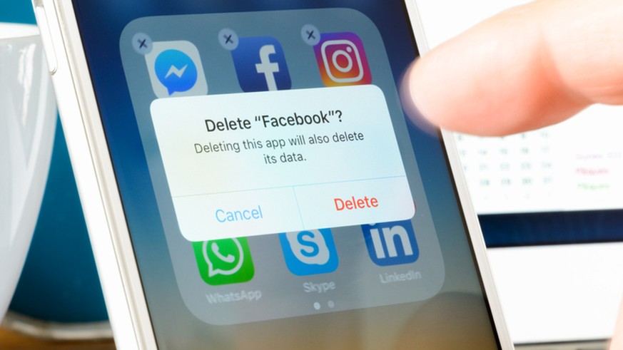 Antibes, France - February 22, 2018: User deletes Facebook app from iPhone. The social media platform faces increased scrutiny around personal data privacy and its handing of fake news and extremist c ...