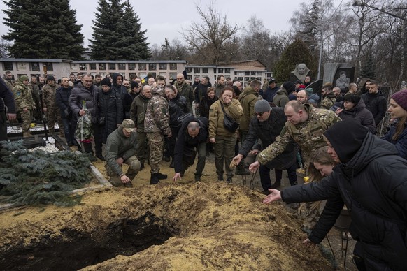 30.12.2022, Ukraine, Charkiw: Ukrainische Soldaten des Khartia-Bataillons verabschieden ihre Kameradin Vladyslava Chernyh während einer Trauerfeier auf dem Friedhof. Chernyh wurde bei einem Gefecht zw ...