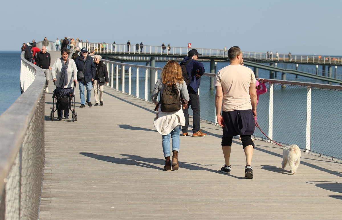 Touristen gehen am Donnerstagnachmittag bei Temperaturen über 15 Grad und Windstille über die Maritim Seebrücke Timmendorfer Strand. Timmendorfer Strand Schleswig-Holstein *** Tourists walk across the ...