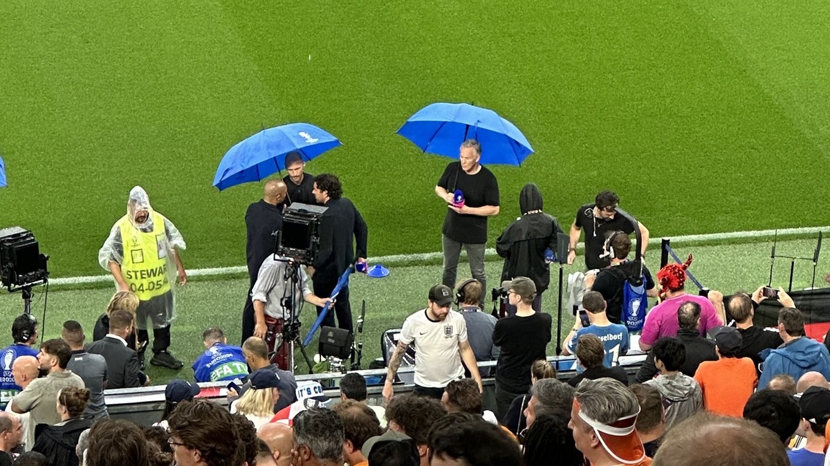 Die drei Ex-Profis (l.) stehen zusammen, Moderator Johannes B. Kerner daneben allein unter seinem Regenschirm.