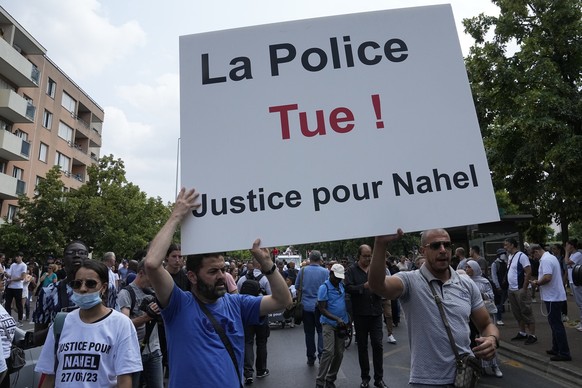 29.06.2023, Frankreich, Nanterre: Demonstranten tragen ein Plakat mit der Aufschrift «Die Polizei tötet, Gerechtigkeit für Nahel» während eines Marsches für den getöteten 17-jährigen Nahel in dem Pari ...