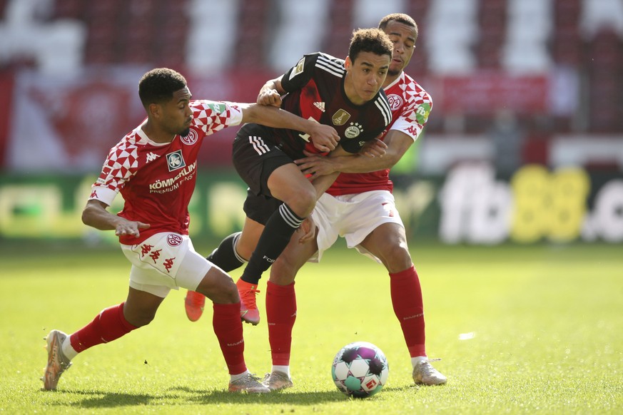 Mainz&#039;s Phillipp Mwene, left, Bayern&#039;s Jamal Musiala and Mainz&#039;s Robin Quaison challenge for the ball during the German Bundesliga soccer match between FSV Mainz and FC Bayern Munich in ...