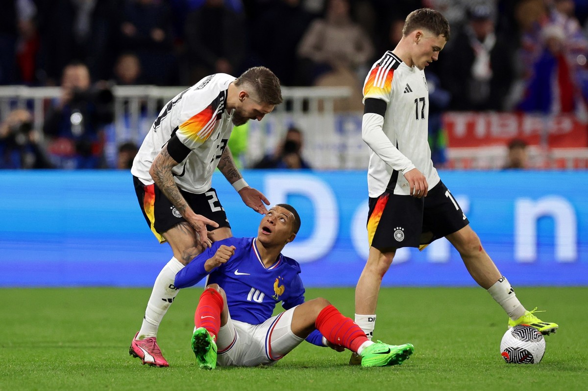 23.03.2024, Frankreich, Lyon: Fu�ball: L�nderspiele, Frankreich - Deutschland, Groupama Stadium. Deutschlands Robert Andrich (l) reagiert neben Frankreichs Kylian Mbapp� (M) und Teamkollege Florian Wi ...