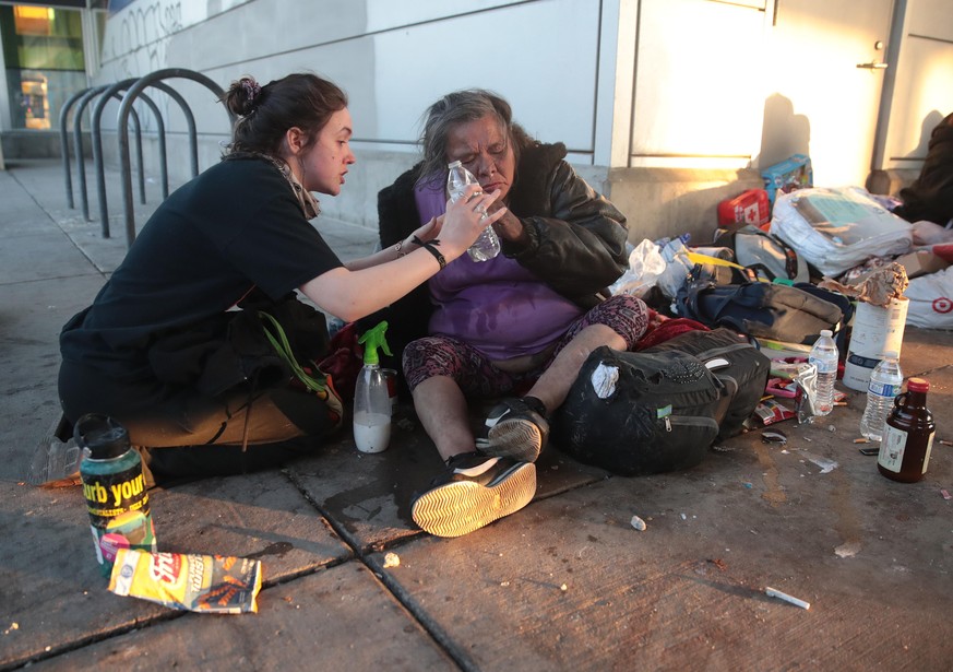 MINNEAPOLIS, MINNESOTA - MAY 29: A woman helps a homeless person recover from being hit by tear gas during a protest sparked by the death of George Floyd while he was in police custody on May 29, 2020 ...
