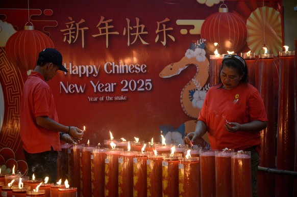 Chinesisches Neujahr, weltweite Eindr�cke von Feierlichkeiten Chinese Lunar New Year Celebrations In Bogor Indonesia A family lights a prayer candle at Dhanagun Temple on the eve of the Chinese Lunar  ...