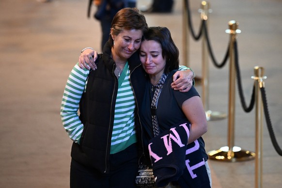 Two women react after paying their respects past the coffin of Queen Elizabeth II as it Lies in State inside Westminster Hall, at the Palace of Westminster in London, Saturday Sept. 17, 2022. (Marco B ...