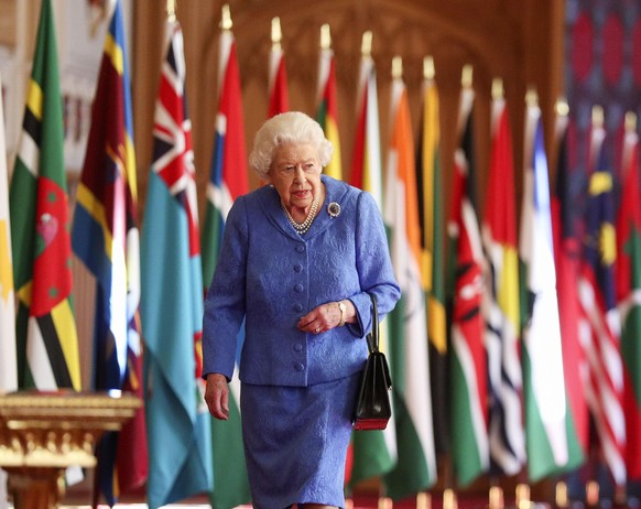 Britain&#039;s Queen Elizabeth II walks past Commonwealth flags in St George&#039;s Hall at Windsor Castle, England to mark Commonwealth Day in this image that was issued on Saturday March 6, 2021. Th ...
