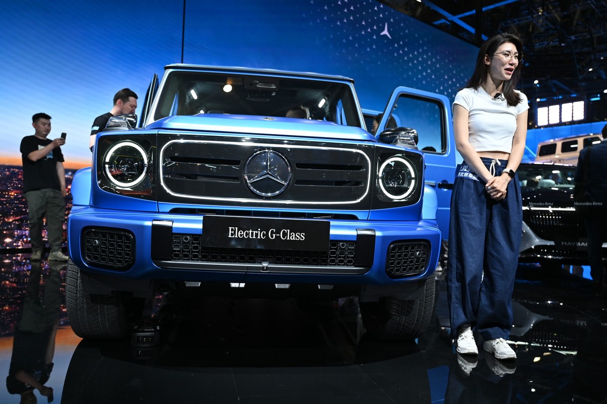 dpatopbilder - 25.04.2024, China, Peking: Eine Frau steht vor einer Mercedes G-Klasse auf der Automesse in China. Die