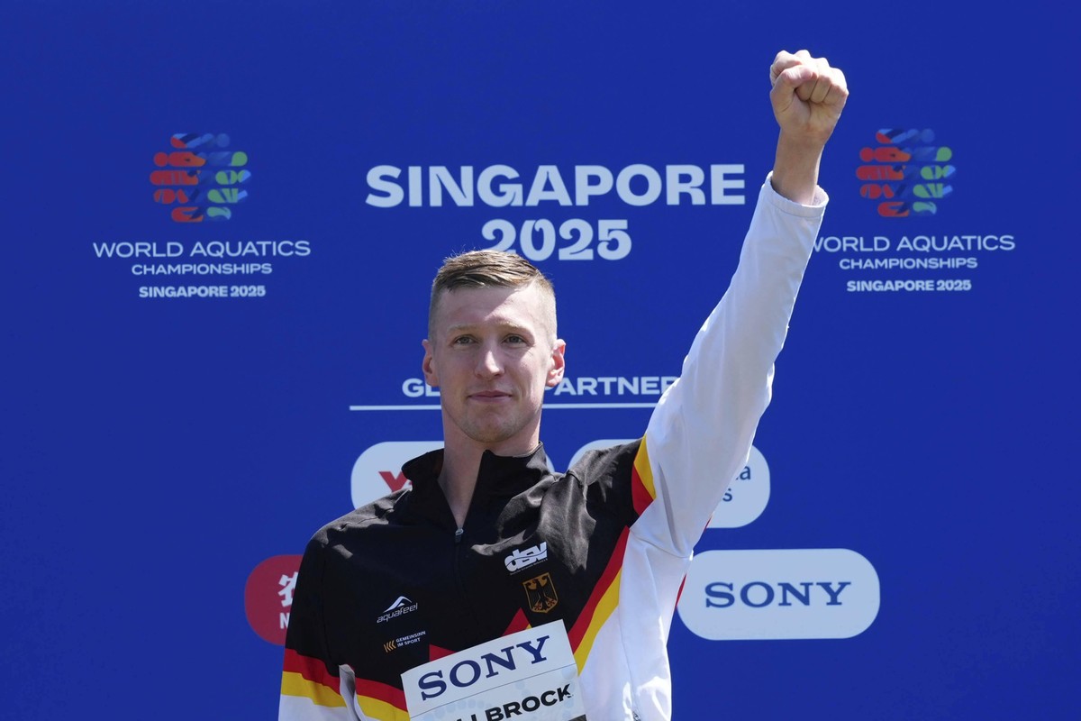 Gold medalist Florian Wellbrock of Germany celebrates on the podium after the men's 5km open water final at the World Aquatics Championships in Singapore, Friday, July 18, 2025. (AP Photo/Vincent ...