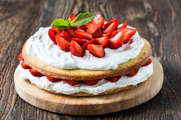 Homemade cream layer cake, fresh, colorful, and delicious dessert with juicy strawberries, and sweet whipped cream.