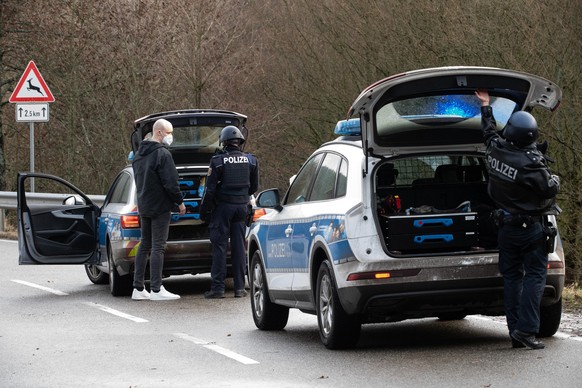 Polizeibeamte stehen an einer Absperrung an der Kreisstraße 22, rund einen Kilometer von dem Tatort entfernt, an dem zwei Polizeibeamte durch Schüsse getötet wurden. Die tödlichen Schüsse fielen nach  ...