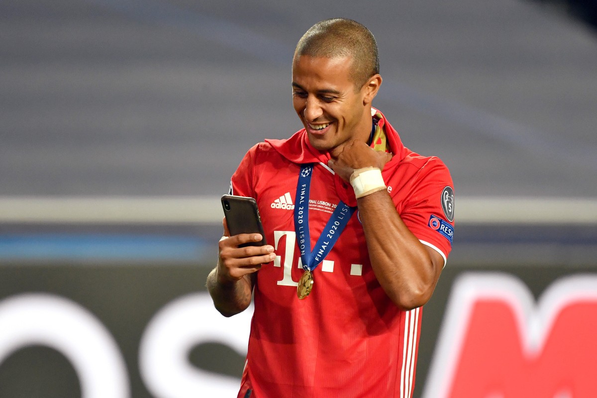Thiago schaut auf sein Smartphone.