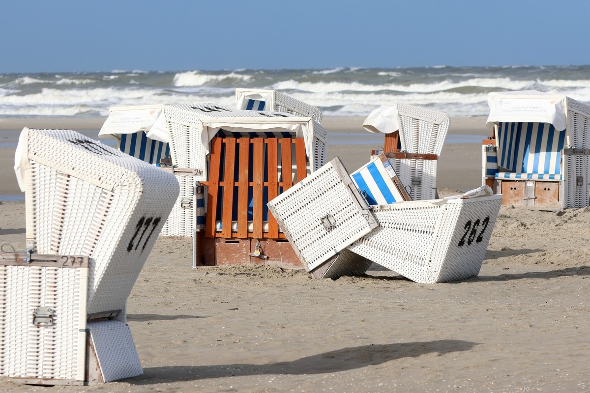 05.08.2025, Schleswig-Holstein, Sankt Peter-Ording: Ein umgekippter Strandkorb liegt am Strand von Sankt Peter Ording bei windig-wechselhaftem Wetter. Foto: Bodo Marks/dpa +++ dpa-Bildfunk +++