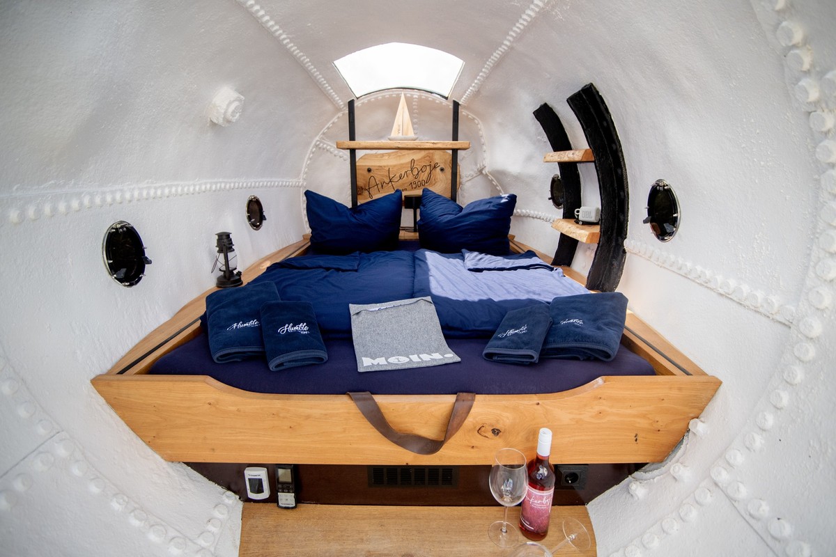 PRODUKTION - 28.06.2024, Niedersachsen, Harlesiel: Ein Bett ist in einer ehemaligen Ankerboje verbaut, die in den D�nen an der Nordseek�ste steht. Seit 2022 k�nnen G�ste in zwei historischen Ankerboje ...