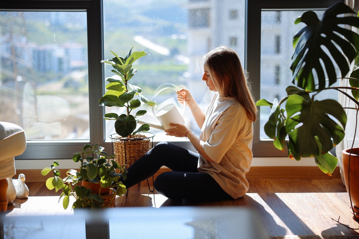 Close up of woman&#039;s hand spraying water on houseplants